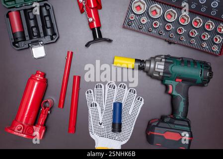 Various auto mechanic tools with cordless impact wrench for mounting and dismounting car wheels on a work table. Stock Photo