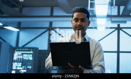 System administrator in data center managing servers, operating systems and software applications. Expert in server hub ensuring networks are secure, up to date, and functioning properly, camera A Stock Photo