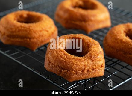 Freshly Placed Donut on a Cooling Rack with Black Background Stock Photo