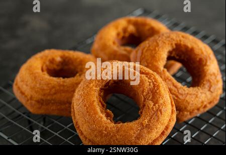 Freshly Placed Donut on a Cooling Rack with Black Background Stock Photo