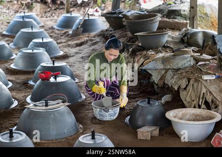 A woman making clay planter pots in a rural workshop in Cho Lach, Vietnam, Monday, November 11, 2024. Photo: David Rowland / One-Image.com Stock Photo