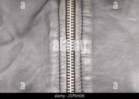 Macro shot of zipper on black leather texture background with stitching. Close-up of black leather material Stock Photo