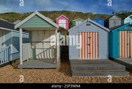 Traditional wooden painted colourful painted beach huts on the shingle beach of Milford on Sea, Hampshire Engalnd, UK Stock Photo