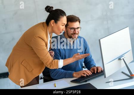 Business professionals collaborating on a project in a modern office. Team of coworkers sharing idea Stock Photo