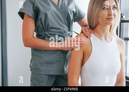 Doing massage. Woman is in health center getting help by doctor. Stock Photo
