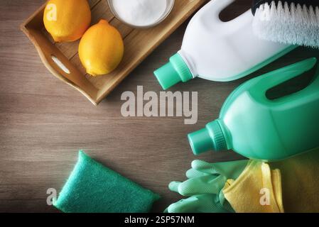 Cleaning products with natural and sustainable ingredients and tools such as disinfectant, scouring pads, cloth and gloves on a wooden table. Top view Stock Photo
