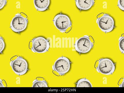 Pattern of white alarm clocks on yellow background Stock Photo