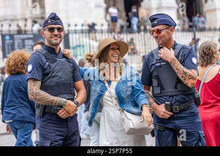 Happy woman posing with two police officers outdoors. Stock Photo