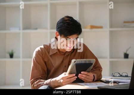 Young man engaged in online learning using a tablet Stock Photo