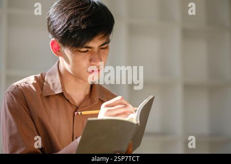Young man studying online and researching financial concepts Stock Photo