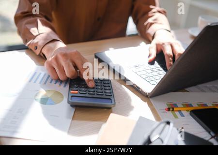 Accountant working on financial calculations using a calculator Stock Photo
