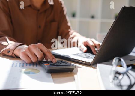 Accountant working on financial calculations using a calculator Stock Photo