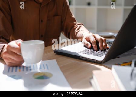 Business reviewing financial data working on a laptop Stock Photo