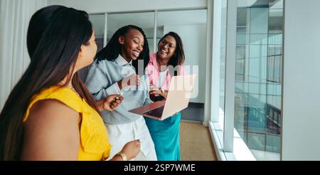 A diverse group of happy coworkers enjoying a light-hearted moment in a modern office. The scene captures the essence of teamwork and collaboration, h Stock Photo