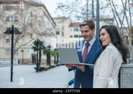 Businesspeople working outdoors using laptop in the city center Stock Photo