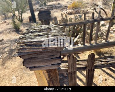 Weathered wooden fence post with rusted nails in desert cemetery Stock Photo