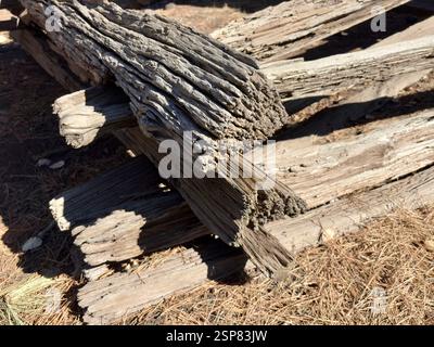 Stacked weathered wooden logs with rough texture in an outdoor setting Stock Photo