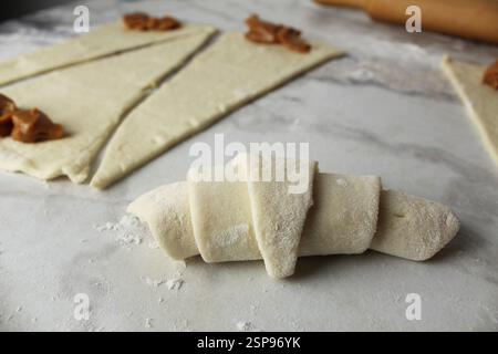 Raw croissant close-up lying on the table side view. Homemade cakes. Stock Photo