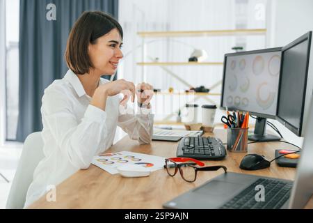 Female designer working in the office by using PC. Stock Photo