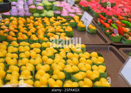 close-up shot of classic Thai golden desserts—Thong Yod (golden drops) and Thong Yip—neatly arranged in banana leaf cups. Stock Photo