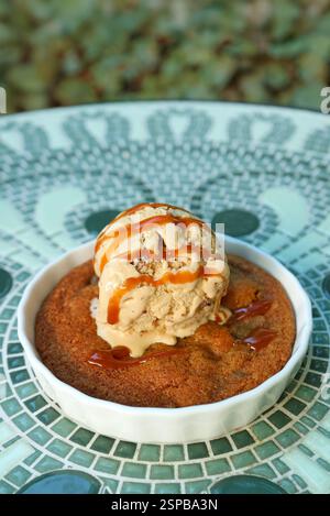 A Plate of Warm Skillet Cookie Topped with Ice Cream and Salted Caramel Sauce Stock Photo