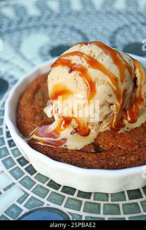 Closeup of Mouthwatering Warm Cookie Topped with Ice Cream and Salted Caramel Sauce Stock Photo