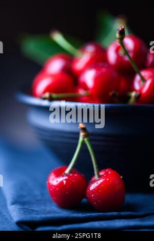 Fresh ripe cherries on blue rustic wooden background. Top view with ...