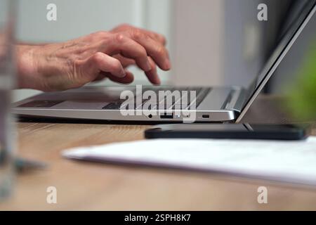 Elderly woman typing text while learning the functions of a text editor Stock Photo