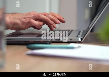 Education at any age: a woman learns new technologies at home Stock Photo