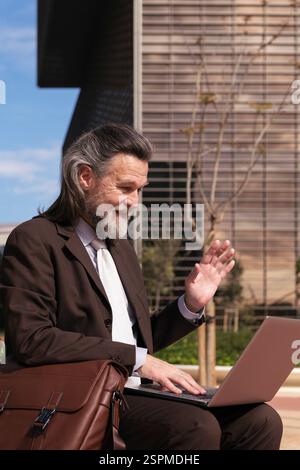 man greeting in online video call on laptop Stock Photo