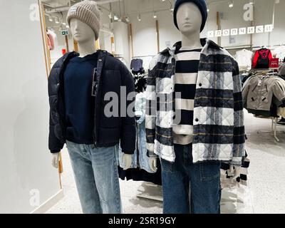 Lviv, Ukraine - February 13, 2025: Mannequins dressed in cozy winter clothing showcased inside a retail store setting Stock Photo