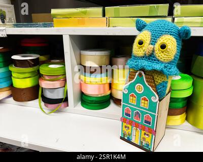Lviv, Ukraine - February 13, 2025: Decorative handmade owl figurine among vibrant craft supplies and colorful ribbons. Stock Photo
