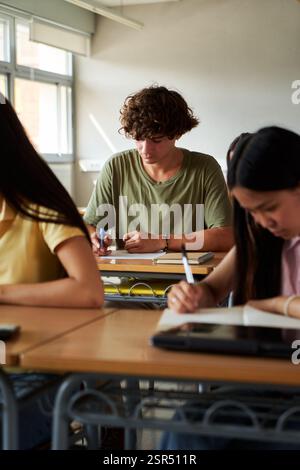 Focused students writing exam in classroom at high school. Stock Photo