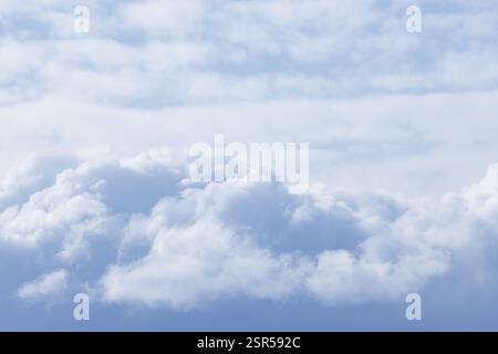 Soft white flurry clouds in a pale winter sky textured background Stock Photo
