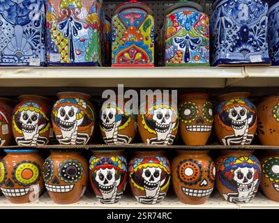 Clay Mexican drinking cups with images of skulls and ceramic canisters made in Mexico. Stock Photo
