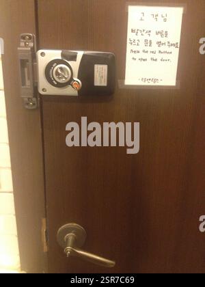 Electronic lock on a door with instructions in Korean and English. Press red button to open. This is a door in South Korea. This door in South Korea h Stock Photo