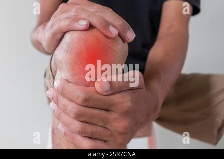Close up view of a man holding his sore or painful knee Stock Photo