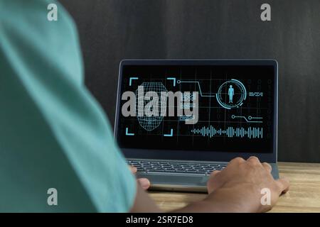 Deepfake and artificial intelligence concept. Man using a laptop to create convincing fake image, video and audio recording. Stock Photo