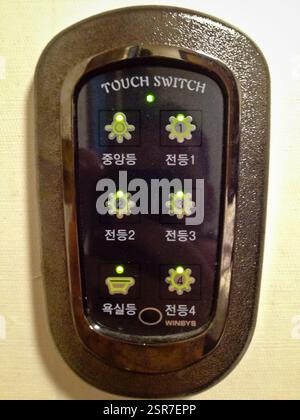 Touch switch with illuminated buttons labeled in Korean and English. Central light, light 1, light 2, light 3, bathroom light, light 4. Possible use i Stock Photo