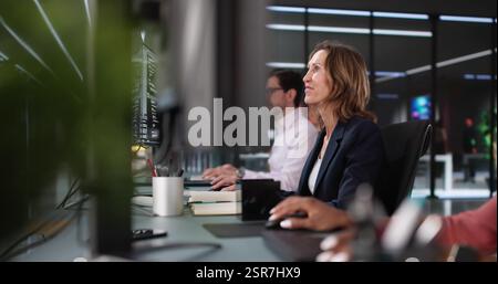 Innovative Programmers Collaborating on Diverse Software Solutions in Office Setting Stock Photo