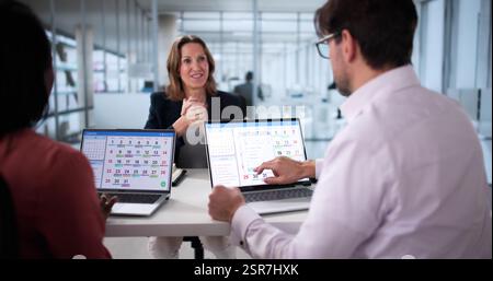 Manager schedules team events using online calendar during virtual meeting. She is a mature African American businesswoman with a laptop. Stock Photo