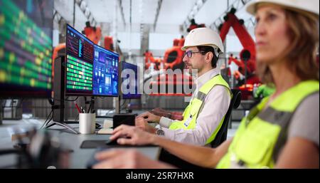 Diverse automotive team works together in factory using Scada system. Stock Photo