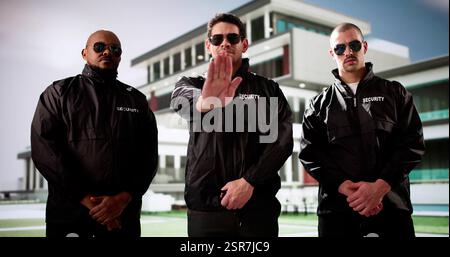 Security Guard Gives Stop Gesture In Front Of Apartment Building. Location: Apartment Building Stock Photo