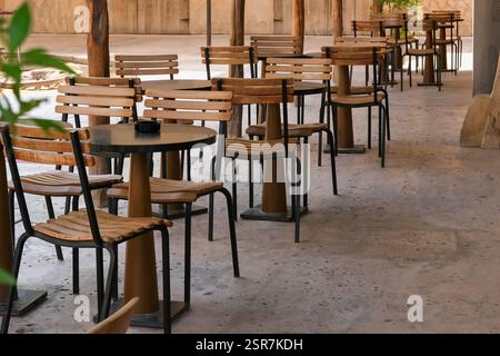 Outdoor street cafe tables ready for service. A row of chairs and tables at open-air coffee shop in Dubai, UAE. Stock Photo