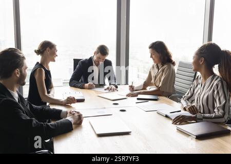 Group of diverse business partners, stakeholders signing contracts Stock Photo