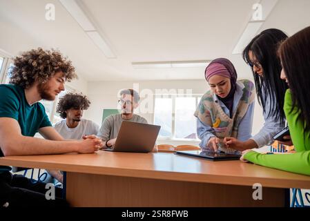 A group of diverse college students studying together or young business team working on a project plan. Stock Photo
