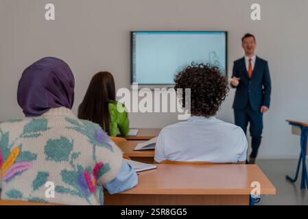 A university lecturer using a smart board to explain a lesson in the classroom. Stock Photo