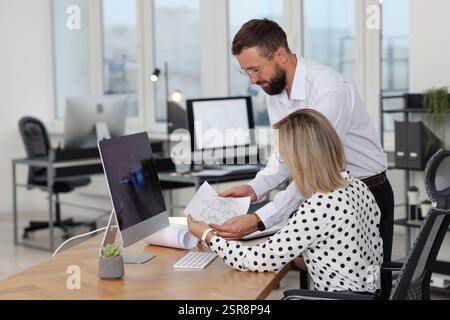 Technicians making digital engineering drawing on computer at desk in office Stock Photo