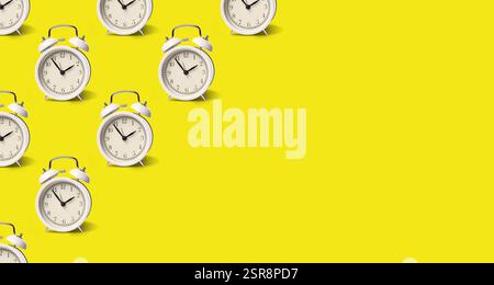 White alarm clocks on yellow background, pattern. Banner design with space for text Stock Photo