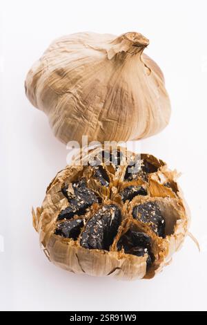 Black garlic cloves isolated on white background Stock Photo
